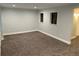 Spacious basement with neutral-toned walls, carpet, and recessed lighting with two window accents at 7565 S Cove Cir, Centennial, CO 80122
