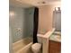 Bathroom features a shower and bathtub with a light blue tile, sink, and toilet at 7565 S Cove Cir, Centennial, CO 80122