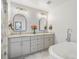 Bright bathroom featuring a double vanity, marble floors, modern fixtures, and a luxurious soaking tub at 810 Jasmine St, Denver, CO 80220