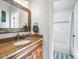 Bright bathroom vanity with granite counters, a large mirror, and a shower-tub combo at 810 Jasmine St, Denver, CO 80220
