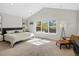 Bedroom with vaulted ceilings, natural light from a large window, and modern furnishings at 810 Jasmine St, Denver, CO 80220