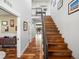 Bright entryway featuring hardwood floors, a wooden staircase, and an open view to the dining room at 810 Jasmine St, Denver, CO 80220