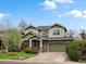Charming two-story home with a well-manicured lawn, stone accents, and an attached garage at 810 Jasmine St, Denver, CO 80220