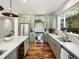 Bright kitchen with a large window, stainless steel appliances, marble countertops, and sage green cabinets at 810 Jasmine St, Denver, CO 80220
