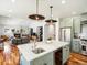Open kitchen with marble island, stainless steel appliances and hardwood floors throughout main level at 810 Jasmine St, Denver, CO 80220