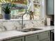 Bright kitchen featuring double sink, gooseneck faucet and marble backsplash with large windows at 810 Jasmine St, Denver, CO 80220