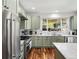 Updated kitchen with stainless steel appliances, sage cabinets, large windows, and marble countertops at 810 Jasmine St, Denver, CO 80220