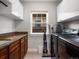 Functional laundry room with granite counters, storage cabinets, window and modern washer and dryer at 810 Jasmine St, Denver, CO 80220