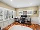 Well lit office with white trim, wood floors and an adjustable desk at 810 Jasmine St, Denver, CO 80220