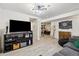 Finished basement with black media center, dartboard and doorway to a gym space at 1049 Lilac St, Broomfield, CO 80020