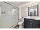 Clean bathroom with a modern vanity, updated walk-in shower, and decorative mirror at 1049 Lilac St, Broomfield, CO 80020