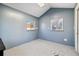 This is an empty room with blue walls and a gray speckled floor with two windows at 1049 Lilac St, Broomfield, CO 80020