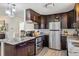 Modern kitchen with updated appliances, granite counters, dark wood cabinetry, and stylish lighting fixtures at 1049 Lilac St, Broomfield, CO 80020