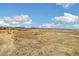 Expansive landscape view featuring open fields, distant mountains, and a clear blue sky with scattered clouds at 1049 Lilac St, Broomfield, CO 80020