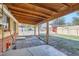 Backyard patio featuring wood beams and a view of the yard and brick fence at 2220 Quebec St, Denver, CO 80207