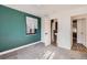 A carpeted bedroom with green walls featuring two doorways at 2220 Quebec St, Denver, CO 80207