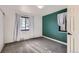 A bedroom with carpeted floors, white walls, and a single green accent wall at 2220 Quebec St, Denver, CO 80207