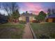 Charming brick home featuring a well-maintained lawn and walkway leading to the front door at 2220 Quebec St, Denver, CO 80207