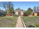 Charming brick home featuring a well-maintained lawn and walkway leading to the front door at 2220 Quebec St, Denver, CO 80207