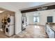 An open concept kitchen and living room feature stainless steel appliances and stone tile flooring at 2220 Quebec St, Denver, CO 80207