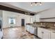 Open-concept floor plan with white kitchen cabinets, mosaic tile, and a view of the living area at 2220 Quebec St, Denver, CO 80207