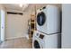 Bright laundry room with stacked washer and dryer next to hot water tank at 2220 Quebec St, Denver, CO 80207