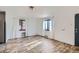 Bright living room featuring wood-look floors and white walls with two large windows and sheer curtains at 2220 Quebec St, Denver, CO 80207