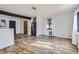 Spacious living area featuring wood-look floors, stainless steel appliances, and white walls at 2220 Quebec St, Denver, CO 80207