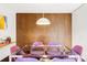 Dining area features wooden wall paneling, a glass table, purple chairs and contemporary lighting fixture at 7170 W 8Th Pl, Lakewood, CO 80214