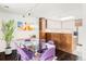 Open dining area with glass table, purple chairs, and modern kitchen in a well-lit space at 7170 W 8Th Pl, Lakewood, CO 80214