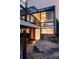 Multi-level modern home with glass windows, stone accents, and a cozy outdoor patio for entertaining at 7170 W 8Th Pl, Lakewood, CO 80214