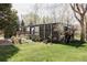 Charming house with wood facade, lush green lawn, mature trees, and inviting wood deck offering a peaceful outdoor setting at 7170 W 8Th Pl, Lakewood, CO 80214