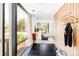 Bright entryway featuring wood paneling, black floors, and a view into the modernly furnished living space at 7170 W 8Th Pl, Lakewood, CO 80214