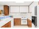 Well-lit kitchen features white appliances, wood cabinets and a countertop with open layout at 7170 W 8Th Pl, Lakewood, CO 80214