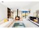 Bright living room featuring a unique fireplace, modern furniture, and access to the outdoor deck with scenic views at 7170 W 8Th Pl, Lakewood, CO 80214