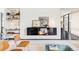 Modern living room featuring floating shelves, stylish decor, and a view into the bright and airy hallway at 7170 W 8Th Pl, Lakewood, CO 80214