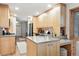 Open-concept kitchen with stainless steel appliances, light wood cabinets, and an island at 11 S Albion St, Denver, CO 80246