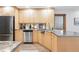 Kitchen with stainless steel appliances, light wood cabinetry, and a stainless steel backsplash at 11 S Albion St, Denver, CO 80246