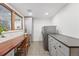 Bright laundry room with patterned tile flooring, gray cabinets, and a convenient built-in desk area by the window at 11 S Albion St, Denver, CO 80246