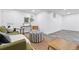 Comfortable living room featuring a green couch, striped ottoman, and large window providing ample natural light at 11 S Albion St, Denver, CO 80246
