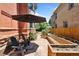Landscaped backyard featuring a stone patio, garden beds, Adirondack chairs, and an umbrella at 1154 N Clarkson St, Denver, CO 80218