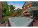 Backyard at dusk with a water feature, patio, lush lawn, and outdoor hot tub at 1154 N Clarkson St, Denver, CO 80218