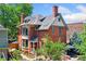Charming brick two-story home with inviting front porch, lush landscaping, and multiple outdoor living spaces at 1154 N Clarkson St, Denver, CO 80218
