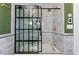 Modern shower with a black grid sliding door, white marble tile surround, and gold shower head at 1154 N Clarkson St, Denver, CO 80218