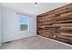 Bedroom with wood accent wall and neutral carpeting at 12773 E 105 Th Pl, Commerce City, CO 80022