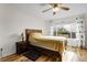 Bedroom with wood floors, large window with curtains, nightstand and reading lamp at 2659 S Halifax St, Aurora, CO 80013
