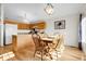 Bright dining area with light wood table, matching chairs, and a view into the kitchen with wood cabinets at 2659 S Halifax St, Aurora, CO 80013
