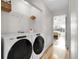 Laundry room featuring modern front-load washer and dryer set, shelving, and hardwood floors at 2659 S Halifax St, Aurora, CO 80013