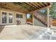 Spacious covered patio with concrete flooring, access to the backyard, and wooden stairs leading to an upper level at 2659 S Halifax St, Aurora, CO 80013