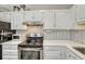 Bright kitchen with stainless steel appliances and white cabinets at 1100 N Marion St # 4, Denver, CO 80218